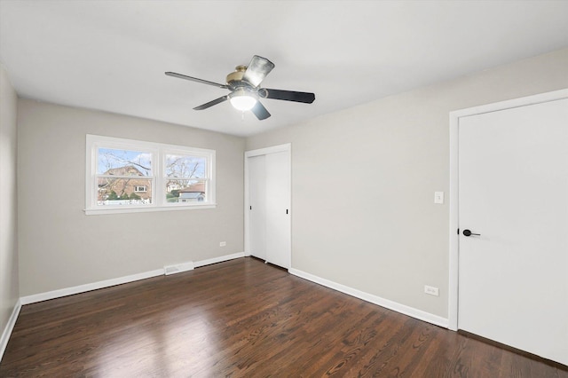 empty room with ceiling fan and dark hardwood / wood-style floors