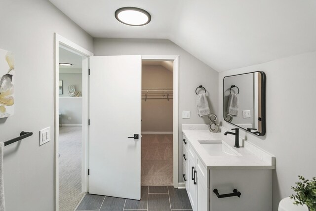 7S135 Clover Ct, Naperville, IL 60540 - bathroom featuring vanity, lofted ceiling, baseboards, and a spacious closet