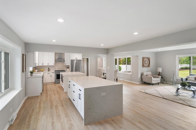 7S135 Clover Ct, Naperville, IL 60540 - kitchen featuring appliances with stainless steel finishes, wall chimney exhaust hood, a center island, light countertops, and plenty of natural light