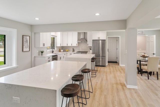 7S135 Clover Ct, Naperville, IL 60540 - kitchen with appliances with stainless steel finishes, wall chimney exhaust hood, a breakfast bar area, a center island, and a sink