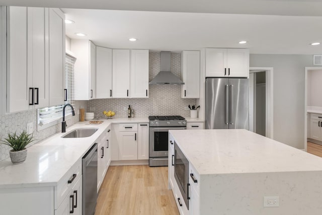 7S135 Clover Ct, Naperville, IL 60540 - kitchen with appliances with stainless steel finishes, a sink, wall chimney exhaust hood, a center island, and light wood-style flooring