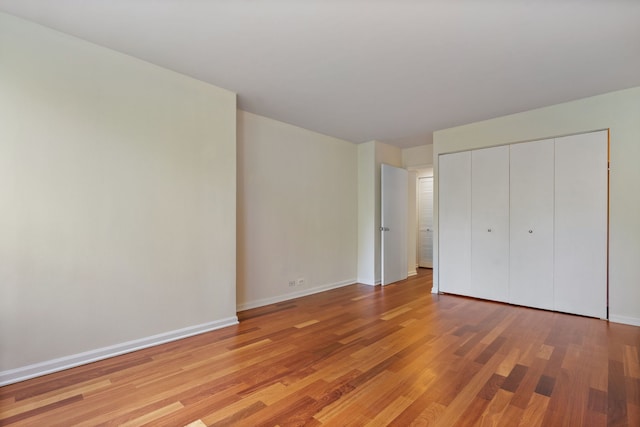 unfurnished bedroom with a closet and light hardwood / wood-style flooring