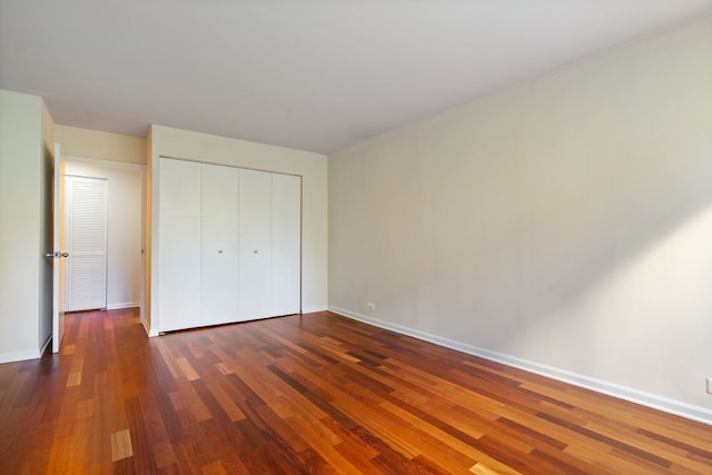 unfurnished bedroom featuring a closet and dark hardwood / wood-style flooring