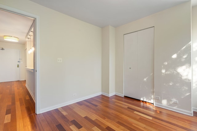 unfurnished bedroom featuring wood-type flooring and a closet