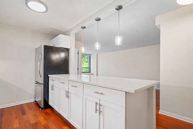 kitchen with dark hardwood / wood-style floors, white cabinetry, hanging light fixtures, and stainless steel refrigerator