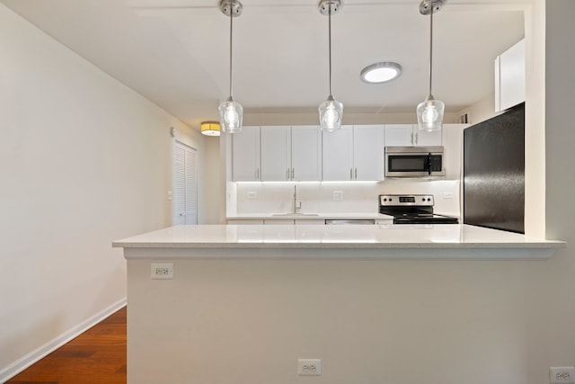 kitchen with sink, dark hardwood / wood-style floors, appliances with stainless steel finishes, light stone counters, and white cabinetry