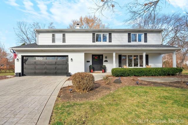 front of property featuring a front yard, a porch, and a garage