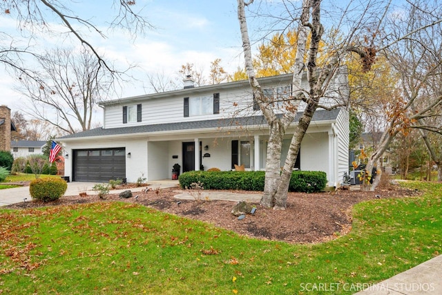 view of front property featuring a front yard, a garage, and covered porch