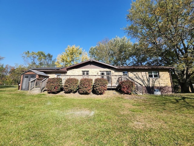 rear view of house with a lawn and a wooden deck