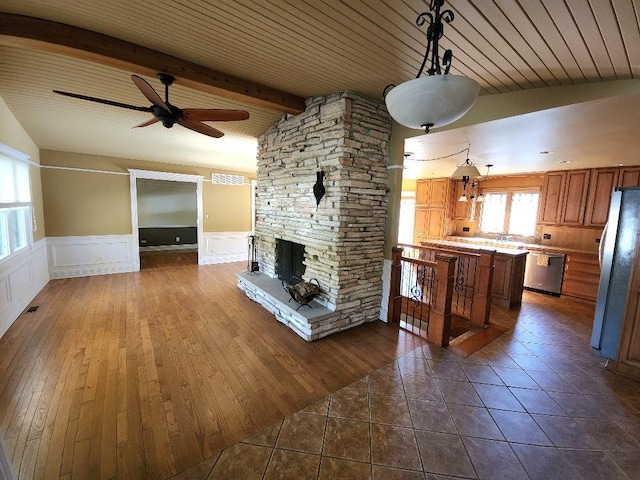 unfurnished living room featuring vaulted ceiling with beams, ceiling fan with notable chandelier, and dark hardwood / wood-style flooring