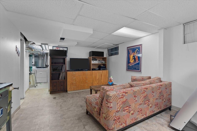 living room with a paneled ceiling and washer and clothes dryer