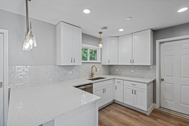 kitchen featuring white cabinets, decorative light fixtures, and light hardwood / wood-style floors