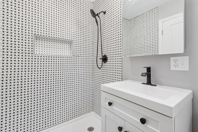 bathroom with vanity and tiled shower