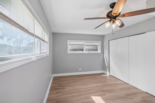 unfurnished bedroom with ceiling fan, a closet, and light hardwood / wood-style floors