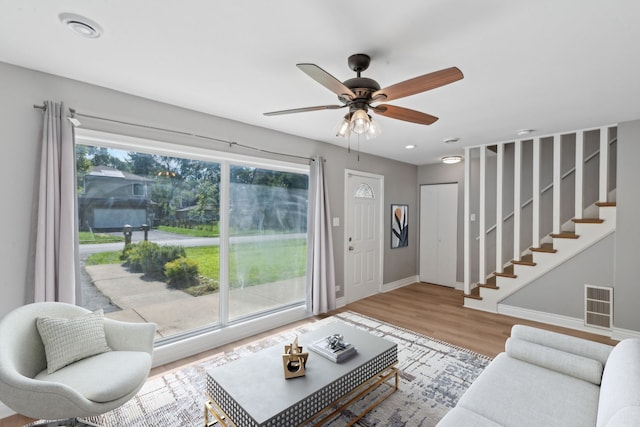 living room with hardwood / wood-style flooring, a wealth of natural light, and ceiling fan