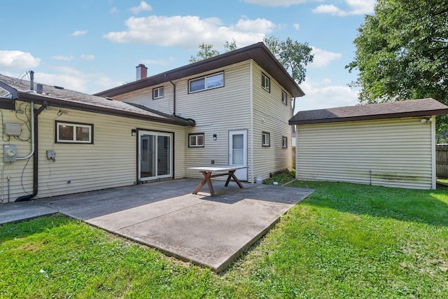 back of property featuring a patio area and a yard