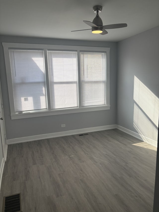 spare room with dark hardwood / wood-style floors and ceiling fan