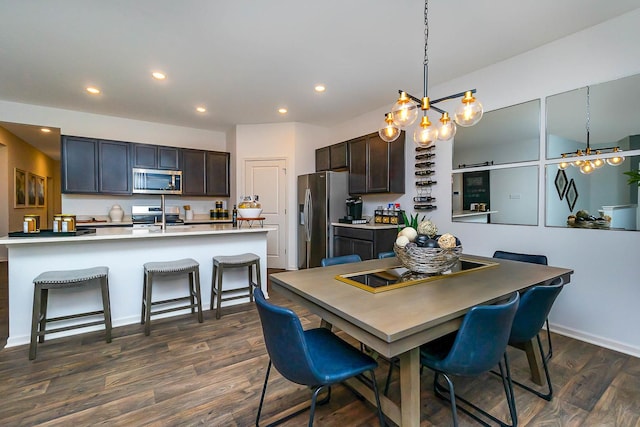 dining space with dark hardwood / wood-style flooring and an inviting chandelier