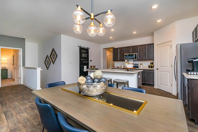 dining area featuring sink, dark wood-type flooring, and an inviting chandelier