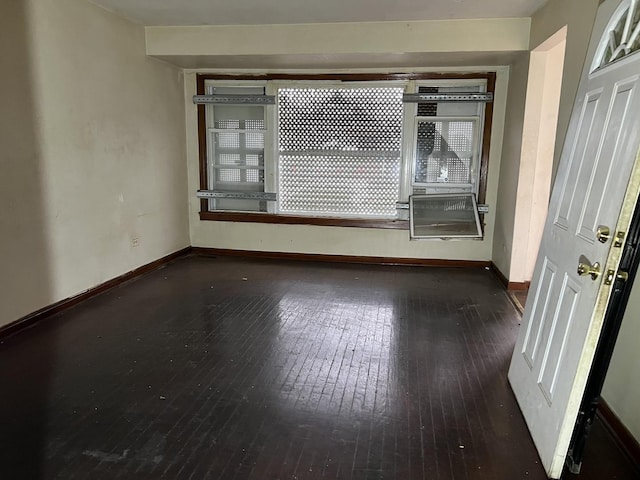 unfurnished room with dark hardwood / wood-style flooring