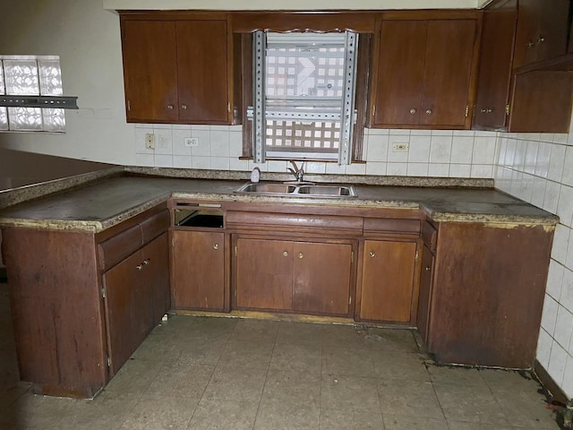 kitchen with backsplash, a healthy amount of sunlight, and sink