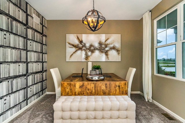 dining area featuring an inviting chandelier and dark colored carpet