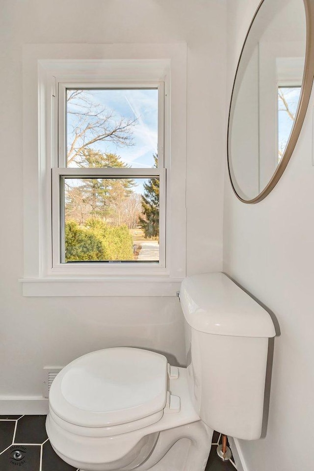 bathroom featuring tile patterned floors, a healthy amount of sunlight, and toilet