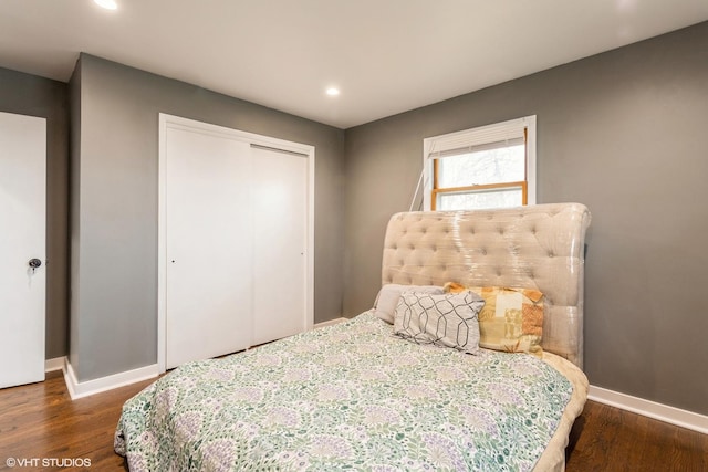 bedroom with dark hardwood / wood-style floors and a closet