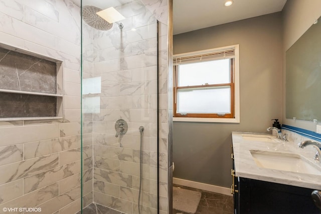 bathroom with a tile shower and vanity