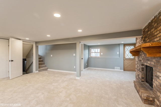 basement with light carpet and a brick fireplace