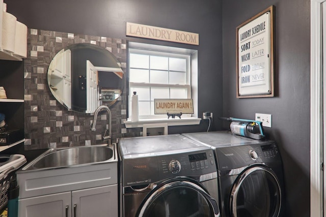 washroom featuring washing machine and clothes dryer, sink, and cabinets