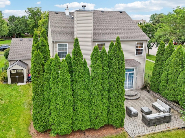 rear view of house with a storage shed and a patio