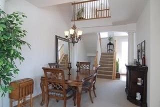 carpeted dining room featuring a chandelier