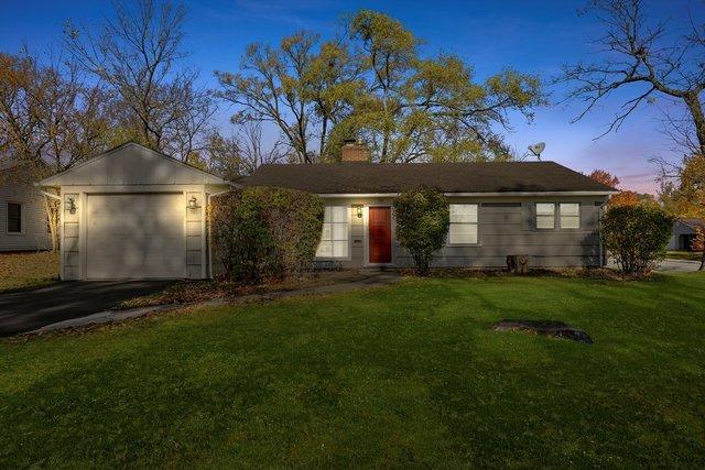 ranch-style home featuring a yard and a garage