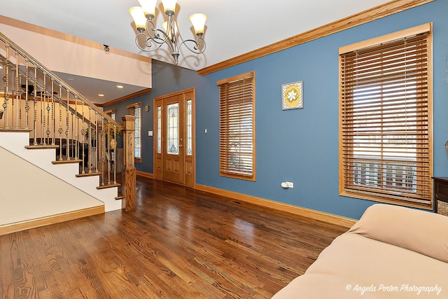 living area with crown molding, hardwood / wood-style floors, and a chandelier