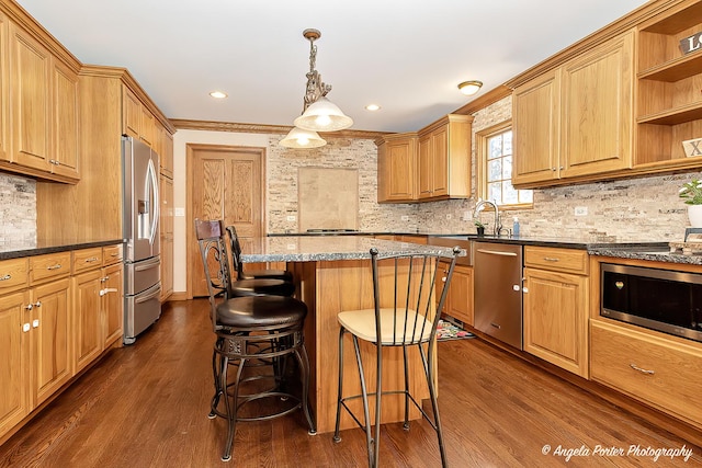 kitchen with a center island, sink, hanging light fixtures, ornamental molding, and dark hardwood / wood-style flooring