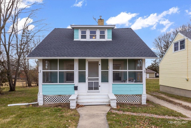 bungalow-style home with a front yard and a sunroom