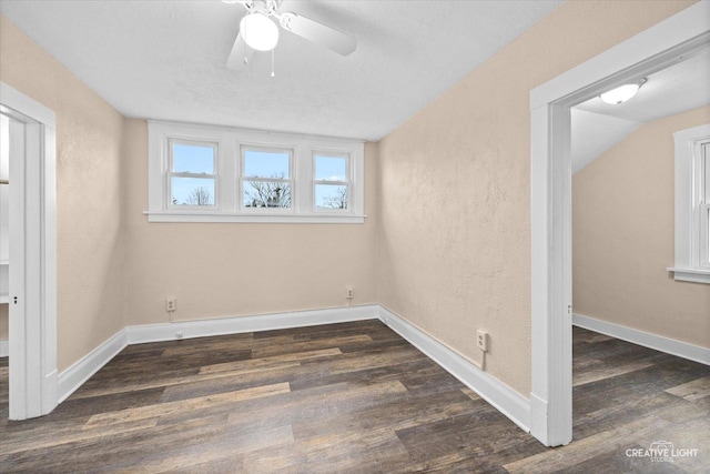 spare room with a textured ceiling, ceiling fan, dark hardwood / wood-style flooring, and vaulted ceiling