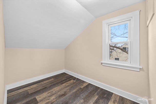 additional living space featuring dark hardwood / wood-style floors and vaulted ceiling