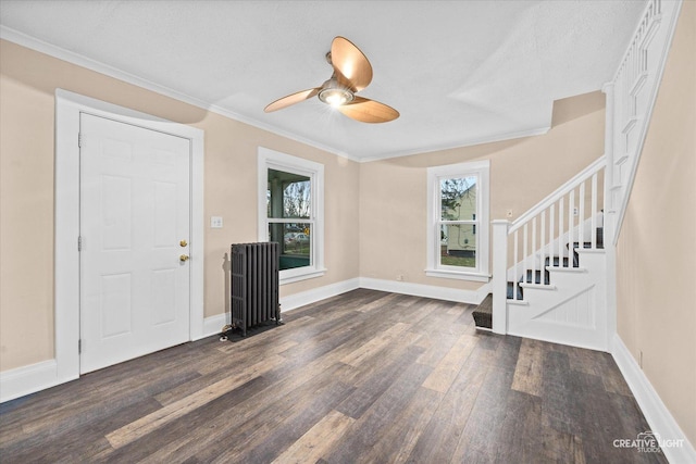 foyer entrance with a textured ceiling, crown molding, ceiling fan, and dark hardwood / wood-style floors