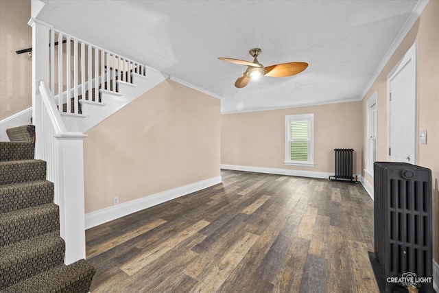 unfurnished living room featuring dark hardwood / wood-style floors, radiator, and crown molding