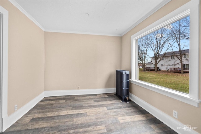 spare room with dark hardwood / wood-style floors, radiator heating unit, and ornamental molding