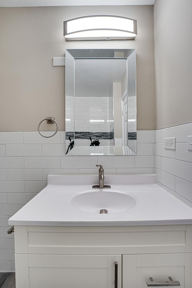 bathroom with vanity and tile walls