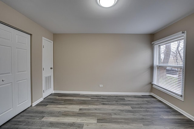 unfurnished bedroom featuring dark hardwood / wood-style flooring and a closet