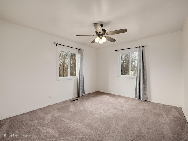 empty room featuring ceiling fan and light carpet