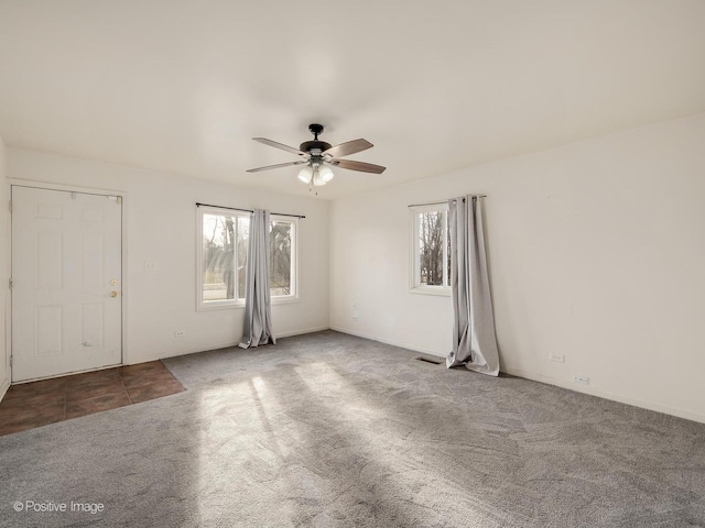 carpeted spare room featuring ceiling fan