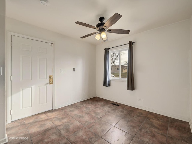 tiled spare room with ceiling fan