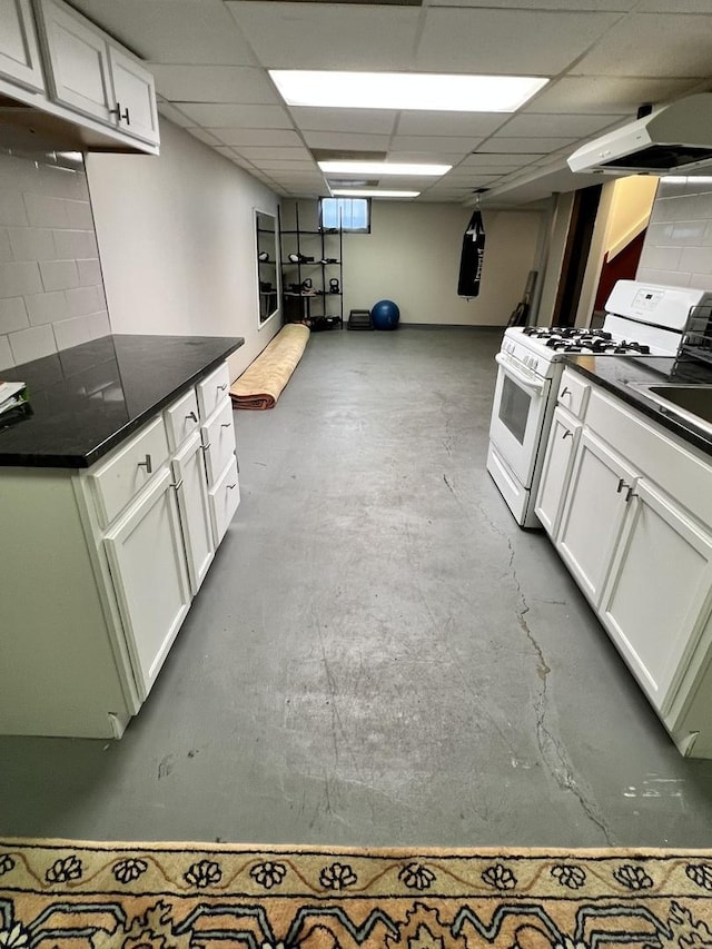 kitchen featuring gas range gas stove, white cabinets, concrete flooring, and ventilation hood