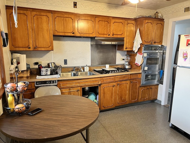 kitchen featuring stainless steel gas cooktop, sink, double oven, and white refrigerator