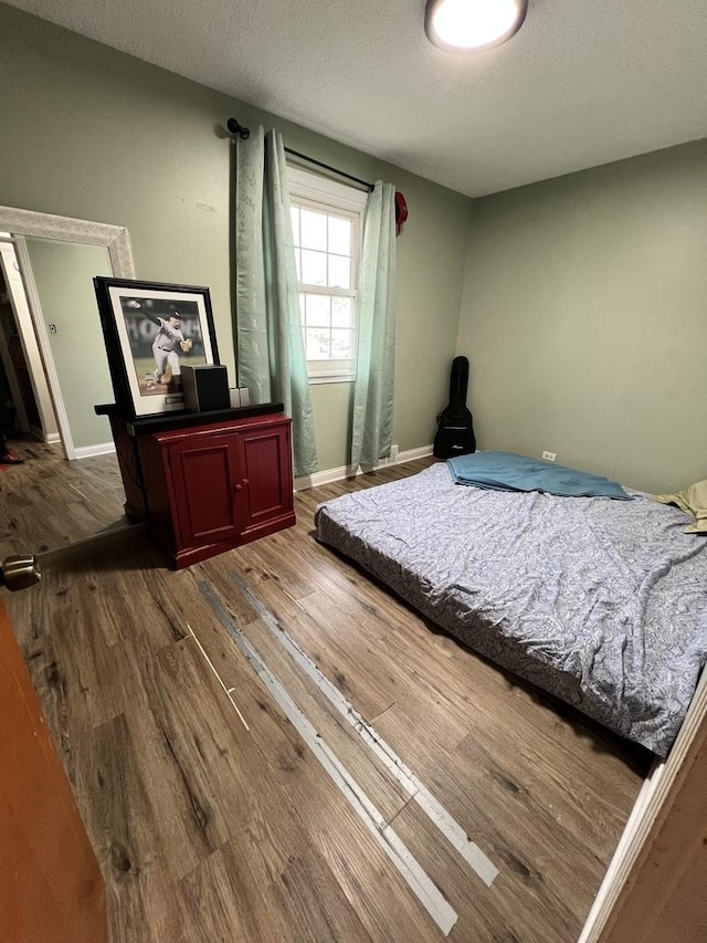 bedroom featuring a textured ceiling and hardwood / wood-style flooring